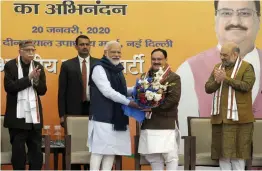  ?? — PTI ?? Prime Minister Narendra Modi greets newly-elected BJP president J.P. Nadda at the BJP HQ in New Delhi on Monday. Veteran party leader L.K. Advani and Union home minister Amit Shah are also seen.