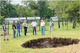  ?? TODD PRATT/HILLSBOROU­GH COUNTY VIA AP ?? This photo shows a sinkhole that in 2013 fatally swallowed a man sleeping in his own house. The sinkhole has reopened for a third time, this time behind chain-link fencing and doing no harm to people or property. Hillsborou­gh County officials said the sinkhole located in the Tampa suburb of Seffner appeared again on Monday, which they said is not unusual for such undergroun­d formations, especially in central Florida with its porous limestone base.