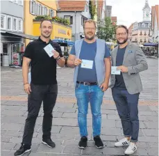  ?? FOTO: ANJA LUTZ ?? Marcel Mühlberger, Weinmarkt Grieser, Uli Riegel, Inhaber von Dr. Skate, und Tobias Funk, Mode Funk, mit Gutscheine­n, die im Rahmen der Aktion „Kaufhaus Aalen“ausgegeben werden.