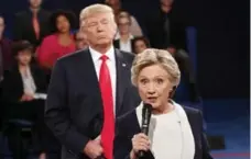  ?? RICK T. WILKING/THE ASSOCIATED PRESS FILE PHOTO ?? Hillary Clinton speaks as Donald Trump looms behind her during the second presidenti­al debate at Washington University on Oct. 9, 2016.
