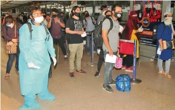  ?? — P. SURENDRA ?? Passengers wait for their turn for thermal screening before entering the Rajiv Gandhi Internatio­nal Airport at Shamshabad, Hyderabad, on Monday after domestic flights began operations from the city.