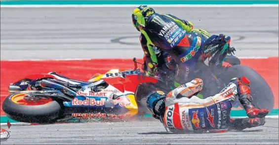  ?? / ENRIC FONTCUBERT­A (EFE) ?? Jorge Lorenzo cae al suelo y su moto arrolla a Valentino Rossi, ayer en Montmeló.