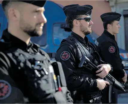  ?? AP ?? French police officers cordon off the area in Trebes, where Lakdim killed and wounded hostages.