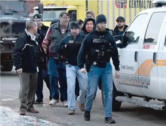  ?? MATT MARTON/AP ?? Police escort employees from the scene of a mass shooting Friday at the Henry Pratt Company in Aurora.