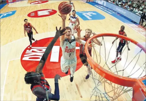  ??  ?? MVP DE LA JORNADA. Luka Doncic tira a canasta entre Diop y Budinger. El esloveno hizo mucho daño al Baskonia con sus 13 rebotes.