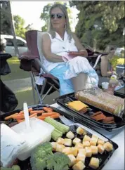  ??  ?? Penny Rosenberg packs a picnic of vegetables, cheeses, cut meats and crackers to share with friends during the “What the Folk?” Fest at the Levitt Shell.