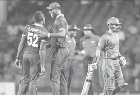  ??  ?? Skipper Carlos Brathwaite congratula­tes bowler Rovman Powell on taking a wicket during Monday’s final Twenty20 Internatio­nal at Warner Park. (Photo courtesy CWI Media)