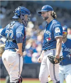  ??  ?? Toronto pitcher R.A. Dickey talks to catcher Josh Thole before being pulled Wednesday during the Blue Jays 8-4 loss to the San Diego Padres at the Rogers Centre in Toronto.