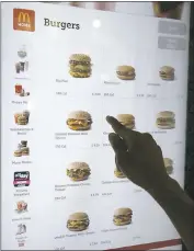  ?? CHARLES REX ARBOGAST — ASSOCIATED PRESS ?? A customer orders food at a self-service kiosk at a McDonald’s in Chicago. The digital-ordering kiosks are part of the company’s efforts to reverse its fading popularity.