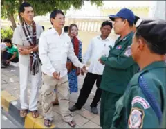  ?? PHA LINA ?? Prey Lang community members speak to police officers outside the Korean Embassy, where they gathered yesterday in Phnom Penh.