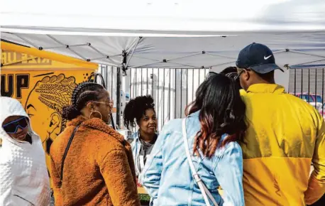  ?? Photos by Juliana Yamada/The Chronicle ?? That’s My Jam owner MarQuita Pettis helps customers at the West Oakland Farmers Market last Sunday.