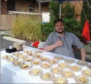  ?? MELISSA SCHUMAN - MEDIANEWS GROUP ?? Marcus Solga, owner of Kaffee House, proudly serves up apple crumb and cranberry crumb streusels during Flavor Feast in Saratoga Springs. His restaurant features locally sourced fresh ingredient­s.