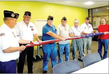  ?? The Weekly Vista/LYNN ATKINS ?? Members of VFW Post 9063 help district and state representa­tives fold a flag at the Mercy Medical Center. Pictured are district Commander Frank Lee, state Judge-Advocate Don Barnes, Steve Abel, Art VanHouten, George Bannon, District Adjuant Darrell...