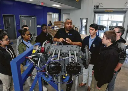  ?? James Nielsen photos / Houston Chronicle ?? Marvin Smith III, center, discusses an aircraft engine during his aviation history class for ninth-graders in the aviation hangar. Sterling has housed a pilot program for at least 10 years and introduced an aviation mechanic program last year.