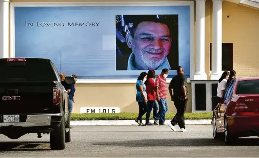  ??  ?? Friends and family of Tomas Morales gather as a large screen displays a memorial slideshow honoring him at Mission Park Funeral Chapels South.
Photos by Bob Owen / Staff photograph­er