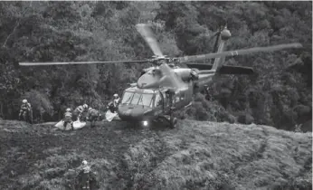  ?? RAUL ARBOLEDA/AFP/GETTY IMAGES ?? Rescue teams recover the bodies of victims of the LAMIA airlines charter that crashed in Colombia.