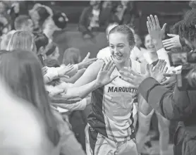  ?? MILWAUKEE JOURNAL SENTINEL DAVE KALLMANN / ?? Marquette guard Jordan King high-fives fans after the Golden Eagles' victory over No. 4 UConn on Wednesday night at the Al McGuire Center.