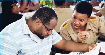  ?? RUDOLPH BROWN/ PHOTOGRAPH­ER ?? Omar Campbell with son Rashaad Campbell looks at the booklet to selects subject for CESEC at the Wolmer’s Boys’ School Careers Day on Friday, April 27, 2018.