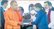  ?? SOURCED ?? CM Yogi Adityanath distributi­ng smartphone­s and tablets to students in Ayodhya on Friday.