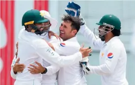  ?? — AFP ?? Pakistan’s Yasir Shah (centre) celebrates the dismissal of Kraigg Brathwaite of the West Indies with team mates on Day Four of the second Test at Kensington Oval in Bridgetown, Barbados, on Thursday.