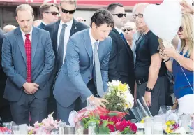  ??  ?? Prime Minister Justin Trudeau places flowers at the Alexander the Great Parkette, near the site of last week’s shootings in Toronto.