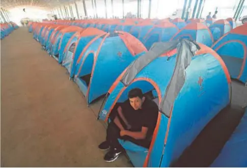  ?? AFP ?? Un emigrante hondureño de la caravana de centroamer­icanos descansa en una tienda en Tapachula (México)