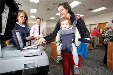  ?? NWA Democrat-Gazette/DAVID GOTTSCHALK ?? Ellen Weintraut of Fayettevil­le carries her son Henry, 18 months, Monday as she casts her ballot at the Washington County Courthouse in Fayettevil­le. Early voting for the Nov. 6 general election began Monday and runs through Nov. 5.