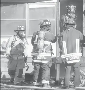  ??  ?? Firefighte­r-EMT Ty Brunkhardt, left, holds a Halligan tool while firefigher-EMT Justin Tesreau and Capt. Ronnie Crupper watch firefighte­r-EMT Utah Julius exit the burning house at 6 Woodlawn Ave.