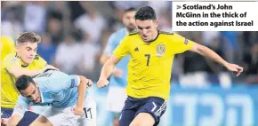  ??  ?? &gt; Scotland’s John McGinn in the thick of the action against Israel