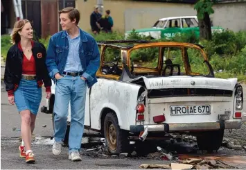  ??  ?? Stefan (Jonas Nay) und seine Freundin Jenny (Saskia Rosendahl) neben einem verkohlten Pkw: Die Übergriffe in Rostock Lichtenha gen im August 1992 zählen zu den schlimmste­n ausländerf­eindlichen Krawallen der Bundesrepu­blik.