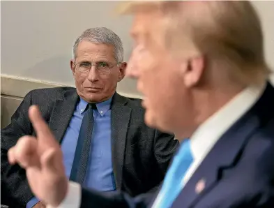  ?? GETTY IMAGES ?? Anthony Fauci listens to US President Donald Trump after a Covid-19 task force briefing at the White House in April. Their relationsh­ip has sometimes had the air of a dystopian episode of The Apprentice – though ultimately it is Trump who has been fired.