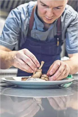  ??  ?? Chef Chris Pyne is shown creating one of the many dishes he calls "elevated rural dining, rooted in sea and soil" from the menu at Founders House Dining and Drinks.