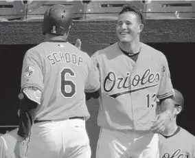  ?? KARL MERTON FERRON/BALTIMORE SUN ?? After just homering himself, Manny Machado greets Jonathan Schoop following his home run. The back-to-back homers came in the third inning off Tampa Bay starter Chris Archer.