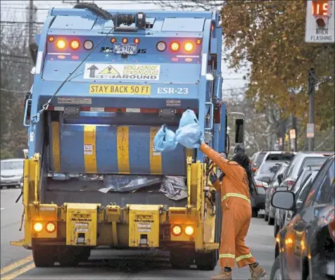  ?? Darrell Sapp/Post-Gazette ?? Blue bags of recycling material are thrown into the back of a garbage truck in this file photo.