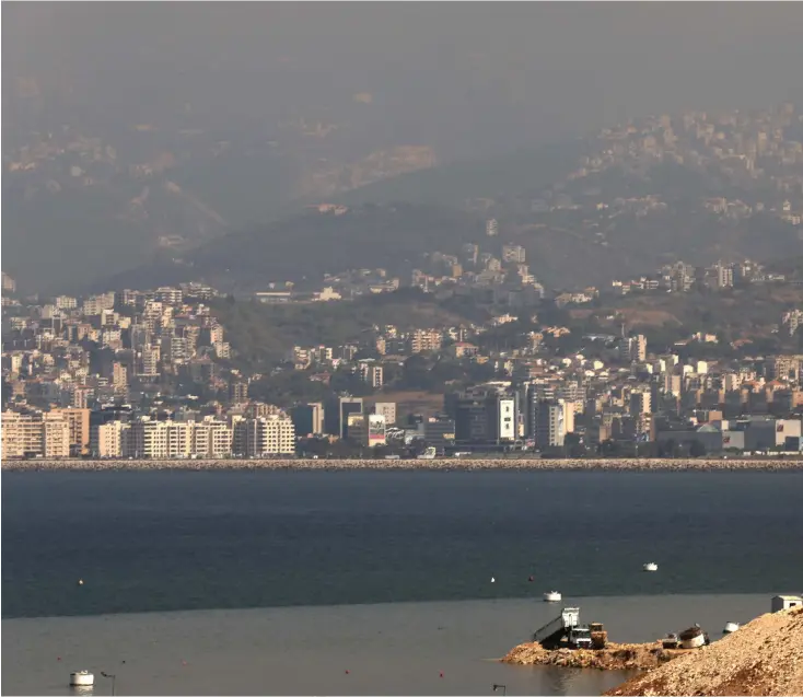  ?? AFP ?? A truck pours earth into the Mediterran­ean Sea to extend the Bourj Hammoud landfill on the outskirts of Beirut, Lebanon