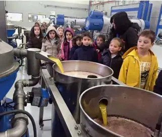  ??  ?? Un grupo de niños realiza una visita guiada por las instalacio­nes de la almazara.