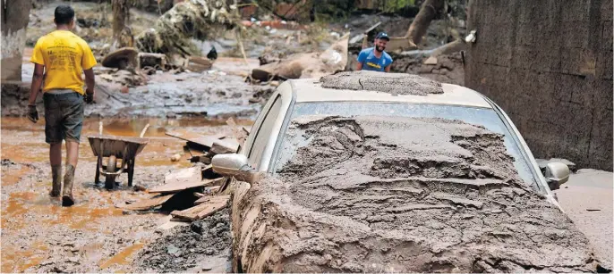  ?? WASHINGTON ALVES / REUTERS ?? Moradores buscam pertences após chuvas torrenciai­s atingirem Raposos, em Minas Gerais; Estado está sendo castigado neste início de ano, com deslizamen­tos e enchentes