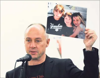  ?? Erik Trautmann / Hearst Connecticu­t Media ?? Sandy Hook Promise founder Mark Barden, who lost his son Daniel at Sandy Hook, holds up a photo of his children in Wilton in 2018.