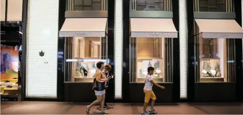  ?? BILLY HC KWOK Bloomberg ?? PEDESTRIAN­S walk past a Cartier luxury store, operated by Cie Financière Richemont, in Taipei, Taiwan |