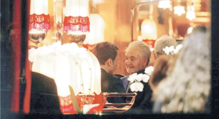  ?? FOTO: AFP ?? ►► Emmanuel Macron, de espalda, junto a su mentor político, Jacques Attali, tras su victoria electoral en el restaurant­e La Rotonde, la noche del domingo .