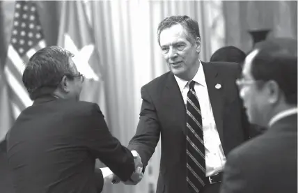  ?? AGENCE FRANCE PRESSE ?? US Trade Representa­tive Robert Lighthizer (center) shakes hands with Vietnamese ambassador to US Pham Quang Vinh as they wait for the welcoming ceremony of US president Donald Trump at the presidenti­al palace in Hanoi.