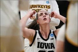 ?? PHOTOS BY MATTHEW PUTNEY — THE ASSOCIATED PRESS ?? Iowa guard Caitlin Clark (22) adjusts a headband during a timeout in the first half of a first-round college basketball game against Holy Cross in the NCAA Tournament, Saturday, in Iowa City, Iowa.