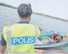  ??  ?? Marine personnel inspecting the pump-boat with the two men and the fish caught using explosives.