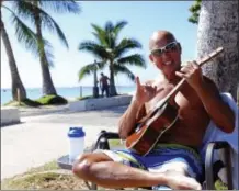  ?? AUDREY MCAVOY — THE ASSOCIATED PRESS FILE ?? Kent Terada shows the shaka or “hang loose” sign while sitting at Ala Moana Beach Park in Honolulu. Americans looking for island getaways without using their passports might consider Hawaii as an alternativ­e to Puerto Rico or the U.S. Virgin Islands...