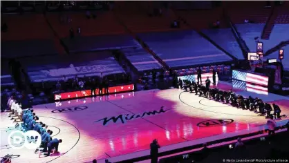  ??  ?? Basketball­er der Miami Heat und der Boston Celtics knien während der Nationalhy­mne