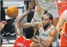  ?? Mark J. Terrill The Associated Press ?? Clippers forward Kawhi Leonard, right, dishes against Hawks defender Clint Capela in the first half of Los Angeles’ comeback victory Monday night.