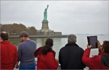  ?? THE ASSOCIATED PRESS ?? Visitors view the Statue of Liberty during a ferry ride to Liberty Island in New York. The U.S. Travel Associatio­n on Thursday said there are “mounting signs” that the Trump administra­tion’s policies are having a “broad chilling effect on demand for...