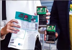  ?? JACK GUEZ/AFP VIA GETTY IMAGES ?? Attendees show off their "green passes" (proof of being fully vaccinated against COVID-19 coronaviru­s disease) as they arrive at Bloomfield Stadium in the Israeli Mediterran­ean coastal city of Tel Aviv on March 5, before attending a concert for vaccinated seniors.