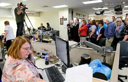  ?? Rebecca Droke/Post-Gazette ?? Photo editor Joyce Mendelsohn at her post as staff photograph­er Andrew Rush instructs staff members preparing to be photograph­ed July 8 in the Post-Gazette newsroom at 34 Blvd. of the Allies.