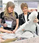  ??  ?? Initiative First Minister Nicola Sturgeon gives out first baby box
